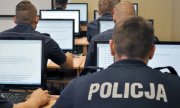 Na fotografii widać policjantów siedzących przed monitorami komputerów
