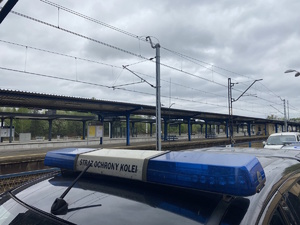 na zdjęciu neon na pojeździe straży ochrony kolei, za nim widoczne perony pkp
