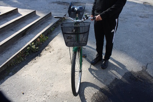 na zdjęciu osoba trzymająca przed sobą rower